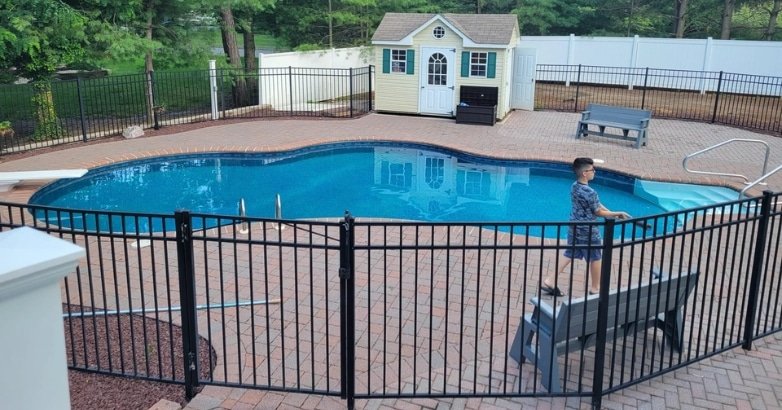 A fenced pool highlighting compliance with New York City and New Jersey pool fencing laws.
