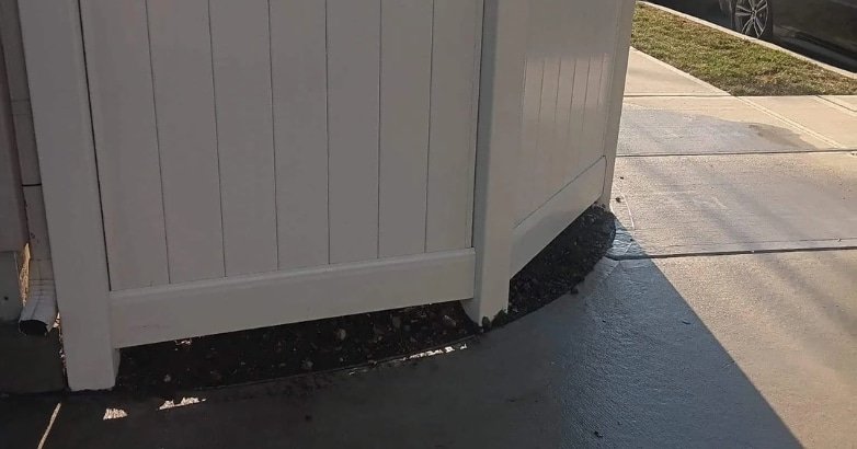 A white fence with a side door, illustrating property line considerations in New York City and New Jersey fencing regulations.