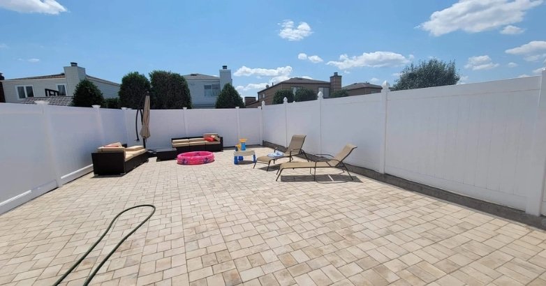 A backyard featuring a white fence, highlighting urban multi-purpose fencing trends.