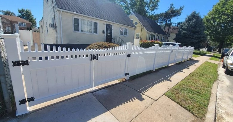 A white fence featuring black pickets and a black gate, illustrating DIY fencing maintenance tips for New York climate.