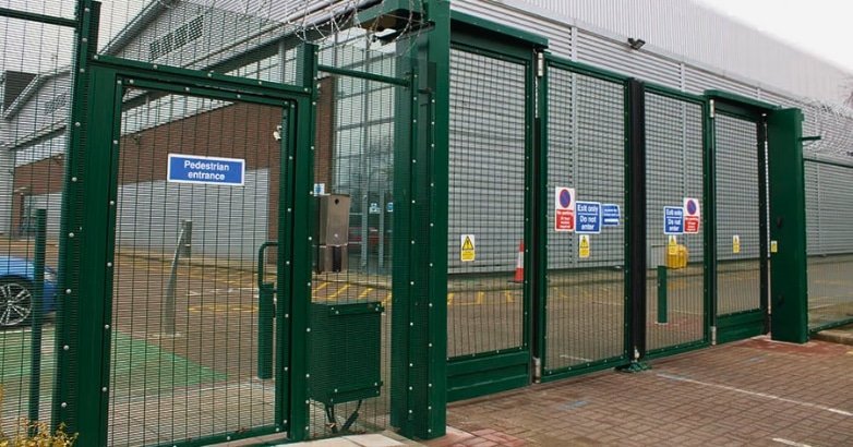 A robust green metal gate featuring a automated gates for modern businesses with fortified security 24/7.