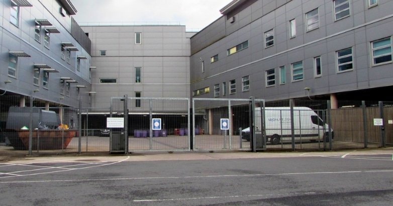 A large building with a modern automated gate and a van parked in front, showcasing scalable tech-smart integration.