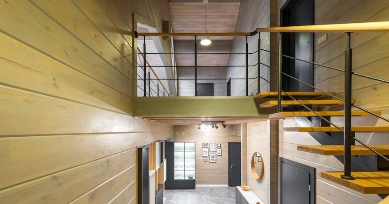 A wooden staircase featuring cable railings, providing access to the second floor of a stylish New York residence.