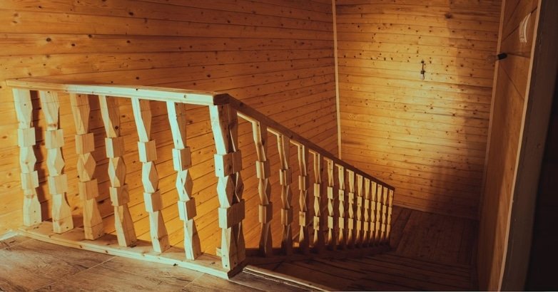 Elegant wooden stairs with traditional balusters in a wooden house, highlighting classic interior design in New York.