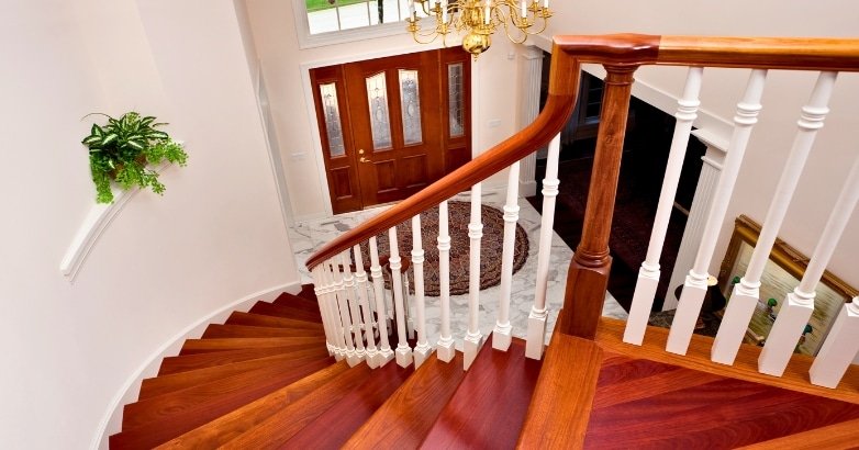 A wooden staircase leading to a door, featuring traditional Colonial railings in a New York interior setting.