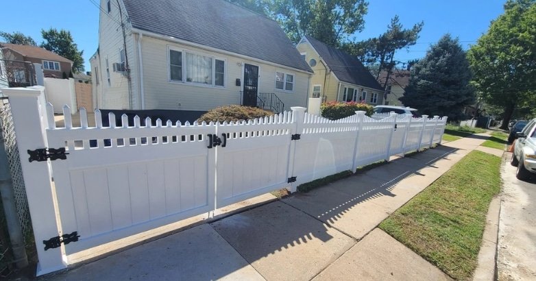 A white picket fence surrounds a house, enhancing its curb appeal and showcasing quality craftsmanship.