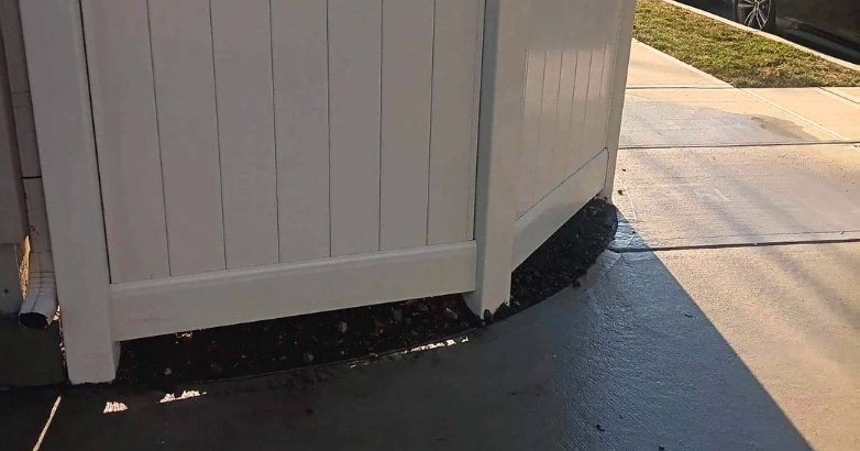 A white fence with a side door, representing a high-quality installation for clear property line definition.
