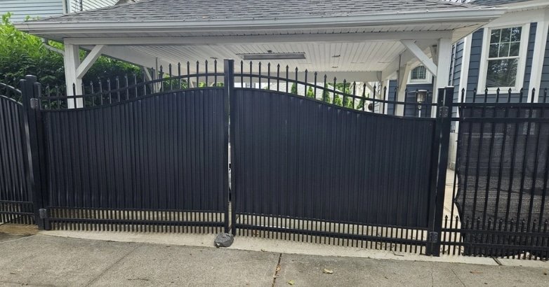 A black wrought iron gate stands in front of a house, emphasizing safety and security for the property.