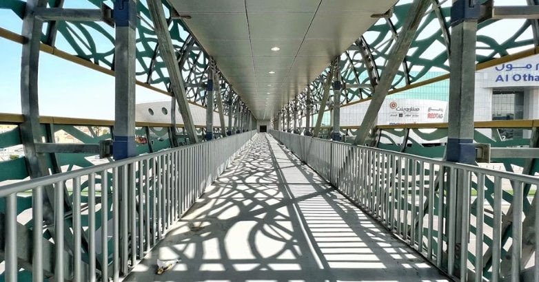 A metal-railed walkway, highlighting the differences in railing materials for indoor and outdoor use.