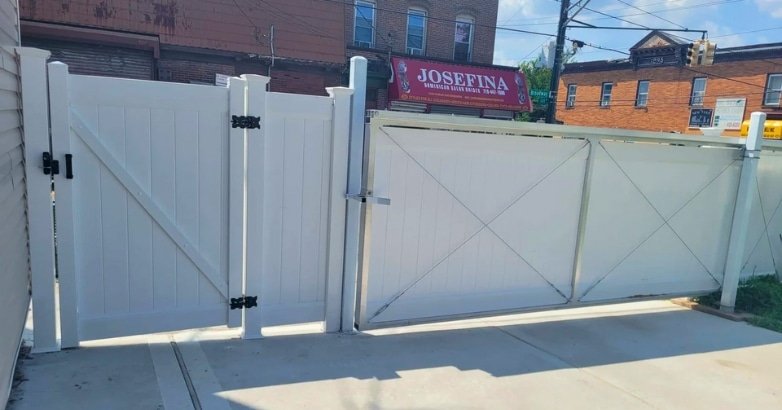 A white sliding gate featuring a decorative sign, enhancing the curb appeal of a residential property.