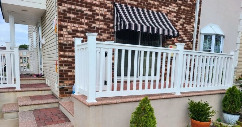 A white railing topped with a black awning, showcasing modern design elements for enhancing home exterior appeal.