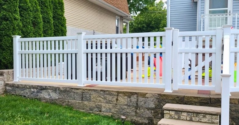 A white fence featuring a wooden railing and steps, illustrating modern and traditional railing styles for home exteriors.