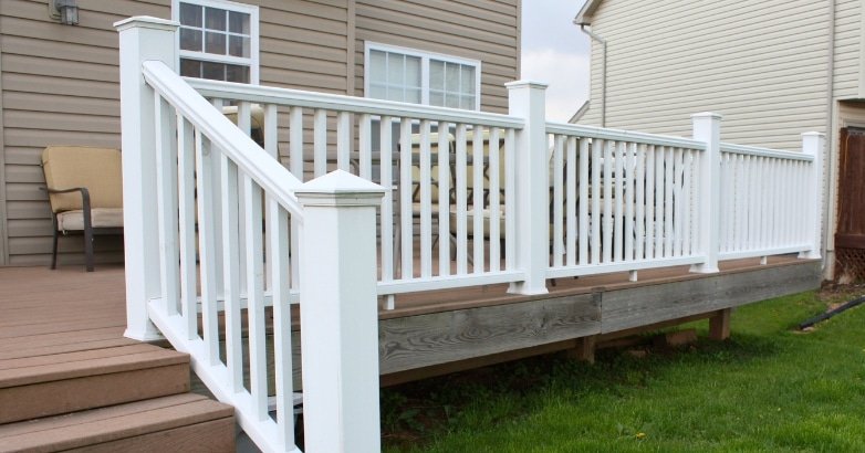 A white deck railing with steps, showcasing a modern design aesthetic for home exteriors.