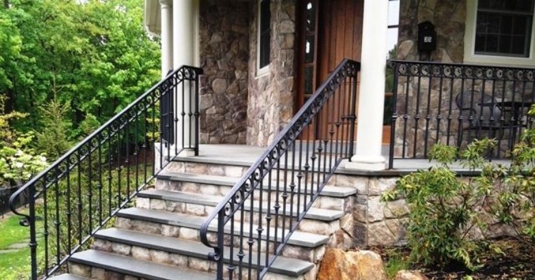 Wrought iron railing on house steps, showcasing a blend of modern and traditional design elements for home exteriors.