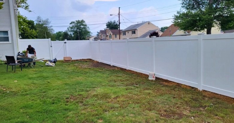 How to Choose the Right Fencing Contractor In The Metro Area JR Fencing A white fence is being constructed in a backyard, illustrating a home improvement project by JR Fencing's contractor.