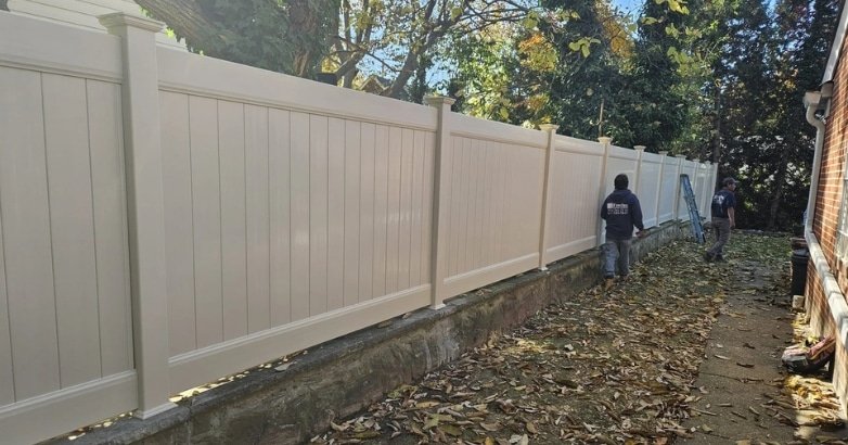 How to Choose the Right Fencing Contractor In The Metro Area Search Locally A yard scene shows a white fence being installed, highlighting the importance of choosing the right fencing contractor.