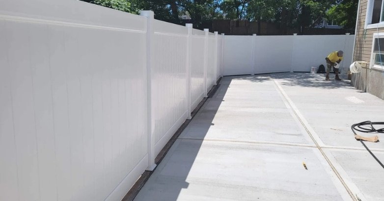 How to Choose the Right Fencing Contractor In The Metro Area Why Matters Installation of a white fence in a backyard, highlighting the importance of choosing the right fencing contractor.