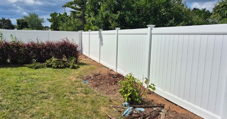 Increasing Property Value with a Custom Designed Fence Maximize Value A white fence surrounds a backyard, enhancing the home's aesthetic and potentially increasing property value.