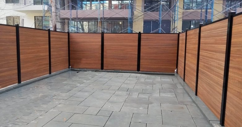 Checklist for Planning a Fencing Project Composite Fence A fence combined with black metal bars, serving as a visual aid for a composite fencing project checklist.