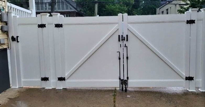 Sloped Driveway Gate Installation Choose the Right Gate Style A white gate with contrasting black hardware, set on a sloped driveway, exemplifying an elegant gate style choice.