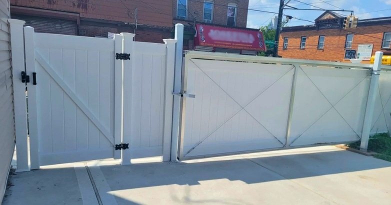 Sloped Driveway Gate Installation Why Professional Expertise Matters A white gate stands open on a sidewalk, highlighting the importance of professional expertise in driveway installations.