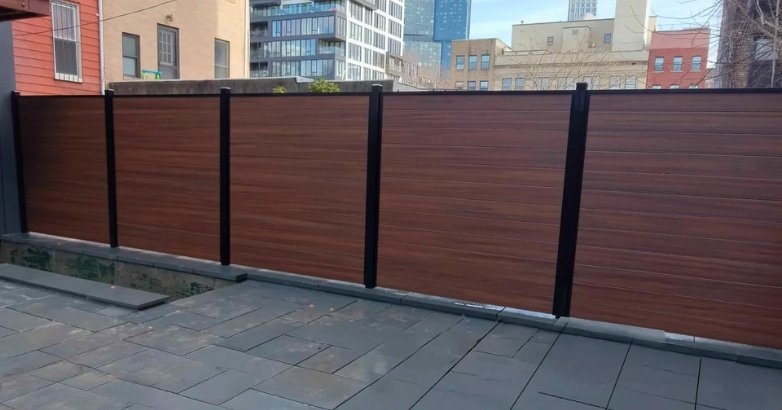 Space Saving Fencing Solutions Horizontal Slat Fencing Horizontal slat wooden fence adjacent to a building, illustrating an efficient fencing design.