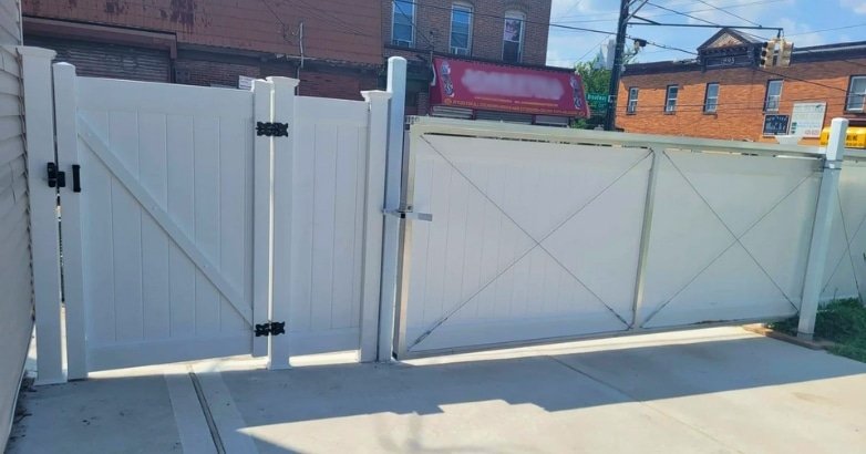 Space Saving Fencing Solutions Sliding Gates A white gate stands open on a sidewalk, illustrating a sliding gate design for efficient space use.