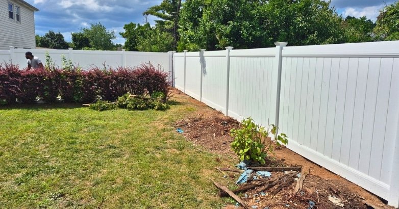 Upgrading Your Old Fence JR Fencing A white fence surrounds the backyard of a house, promoting JR Fencing's services for upgrading old fences.