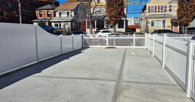Seasonal Fencing Maintenance in New York Fall A white fence borders a house, representing seasonal fencing maintenance in New York for the fall season.